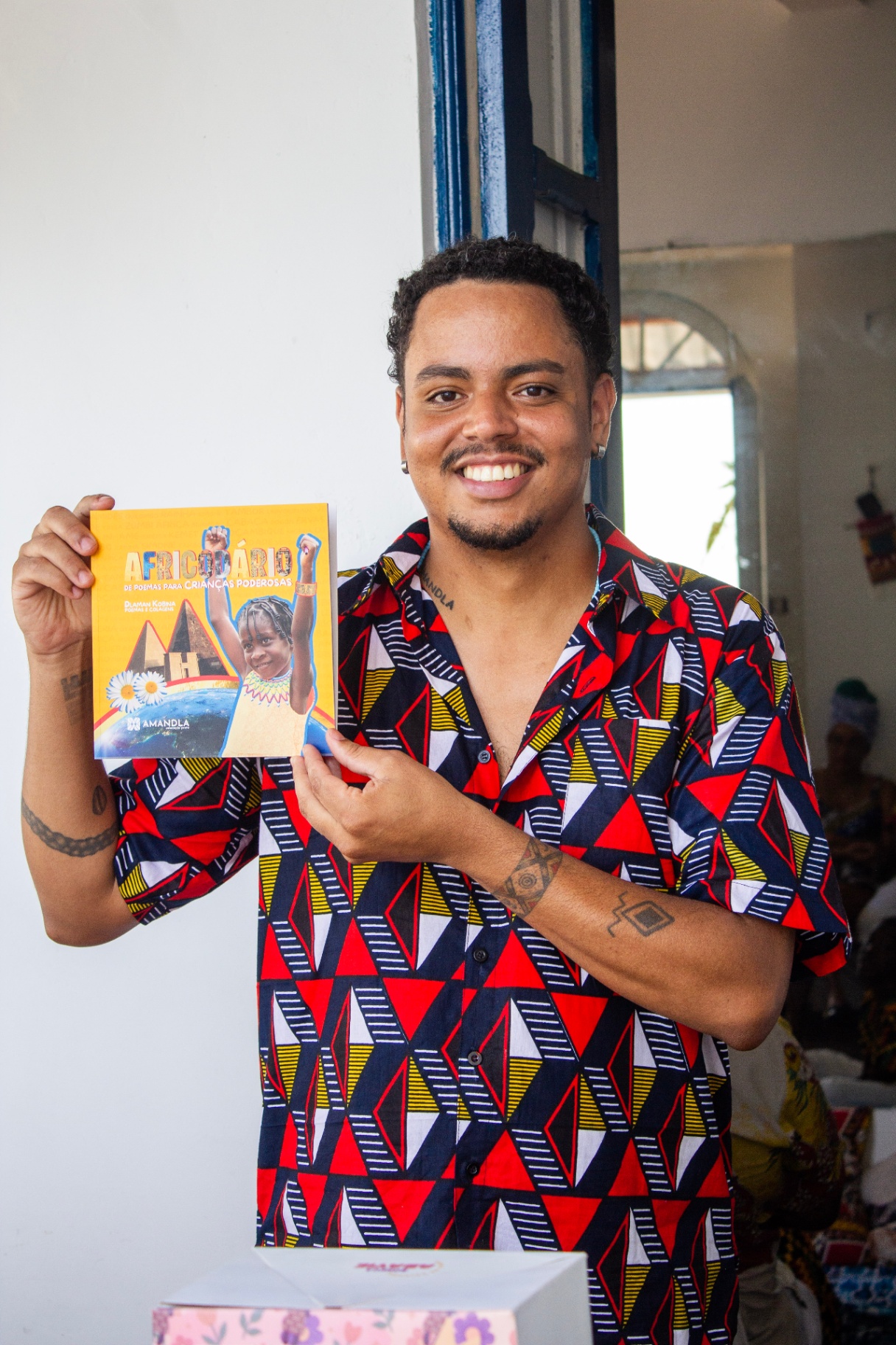 Dlaman Kobina segurando um de seus livros
